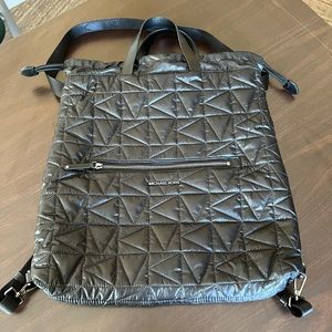 Quilted back pack that has a shoulder strap and handles.